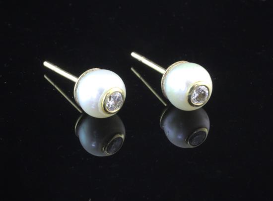 A pair of gold and cultured pearl ear studs, each inset with a round brilliant cut diamond.